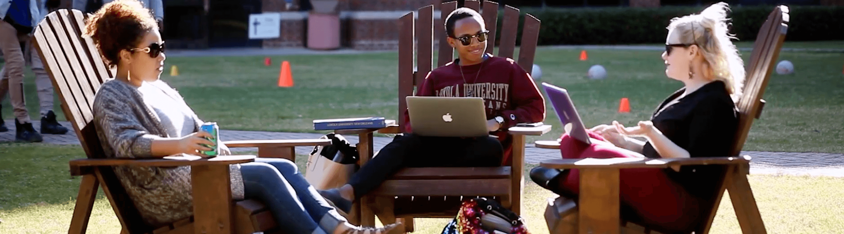 Students on laptops on the lawn