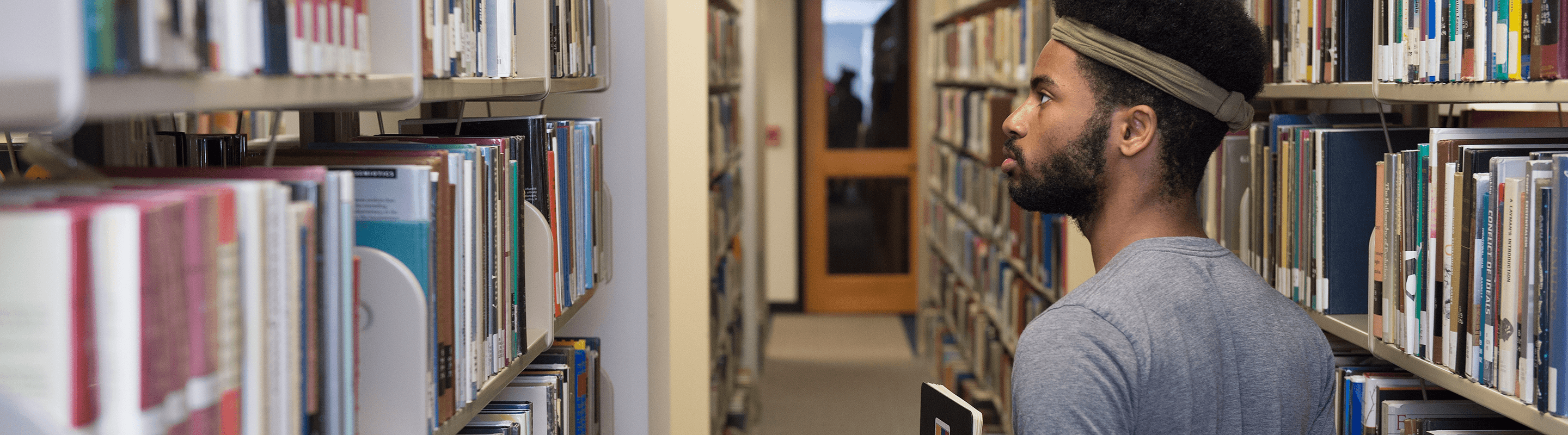 Student looking through books at the library