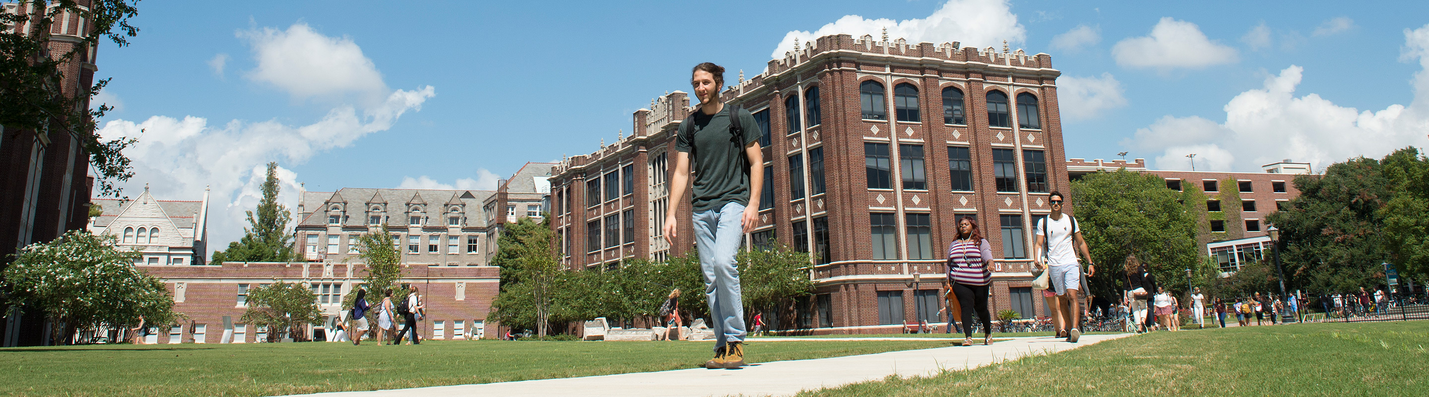 Student walking through academic quad in the middle of the day