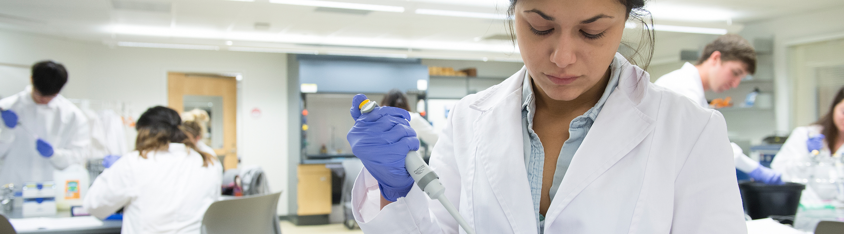 Group of students in lab coats running tests