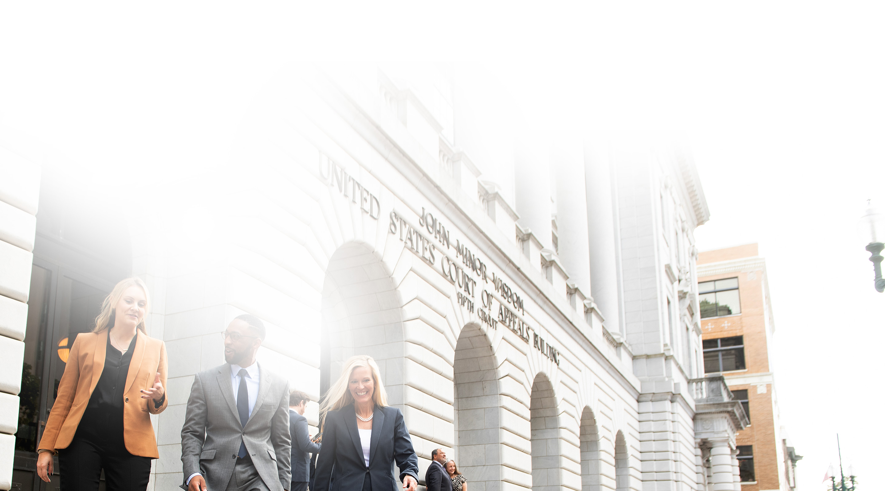 Group of three lawyers walking outside of courthouse