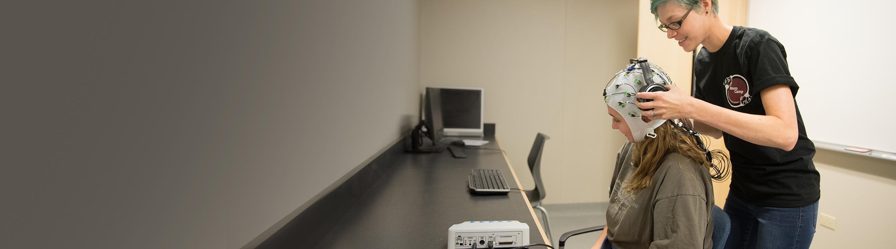 Professor placing eeg machine on student