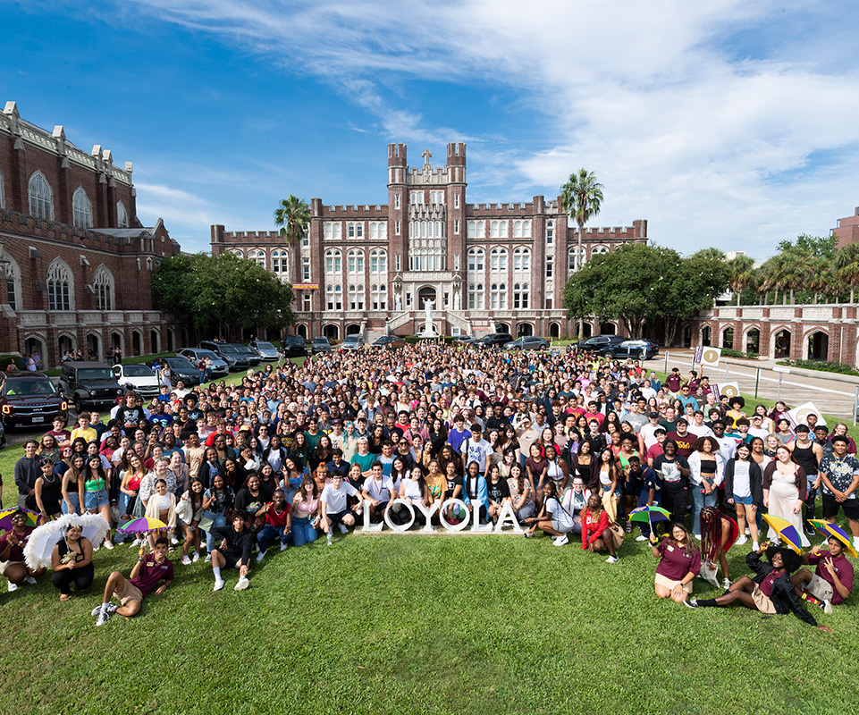 The class of 2026 poses for their class photo by the Loyola sign on the front lawn.
