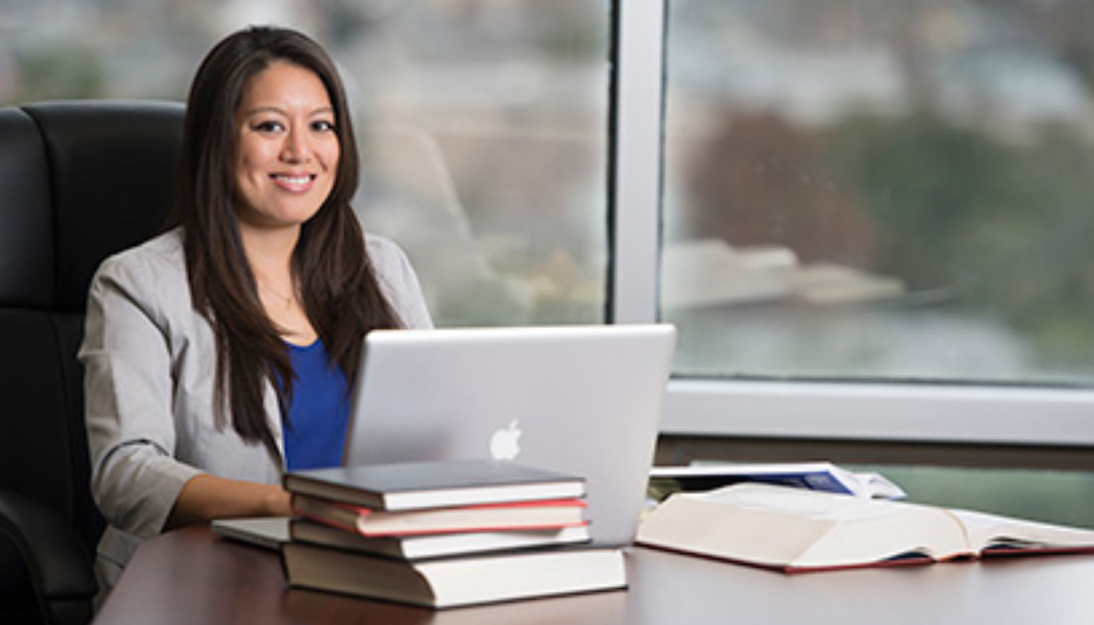 Graduate student studying with laptop and books