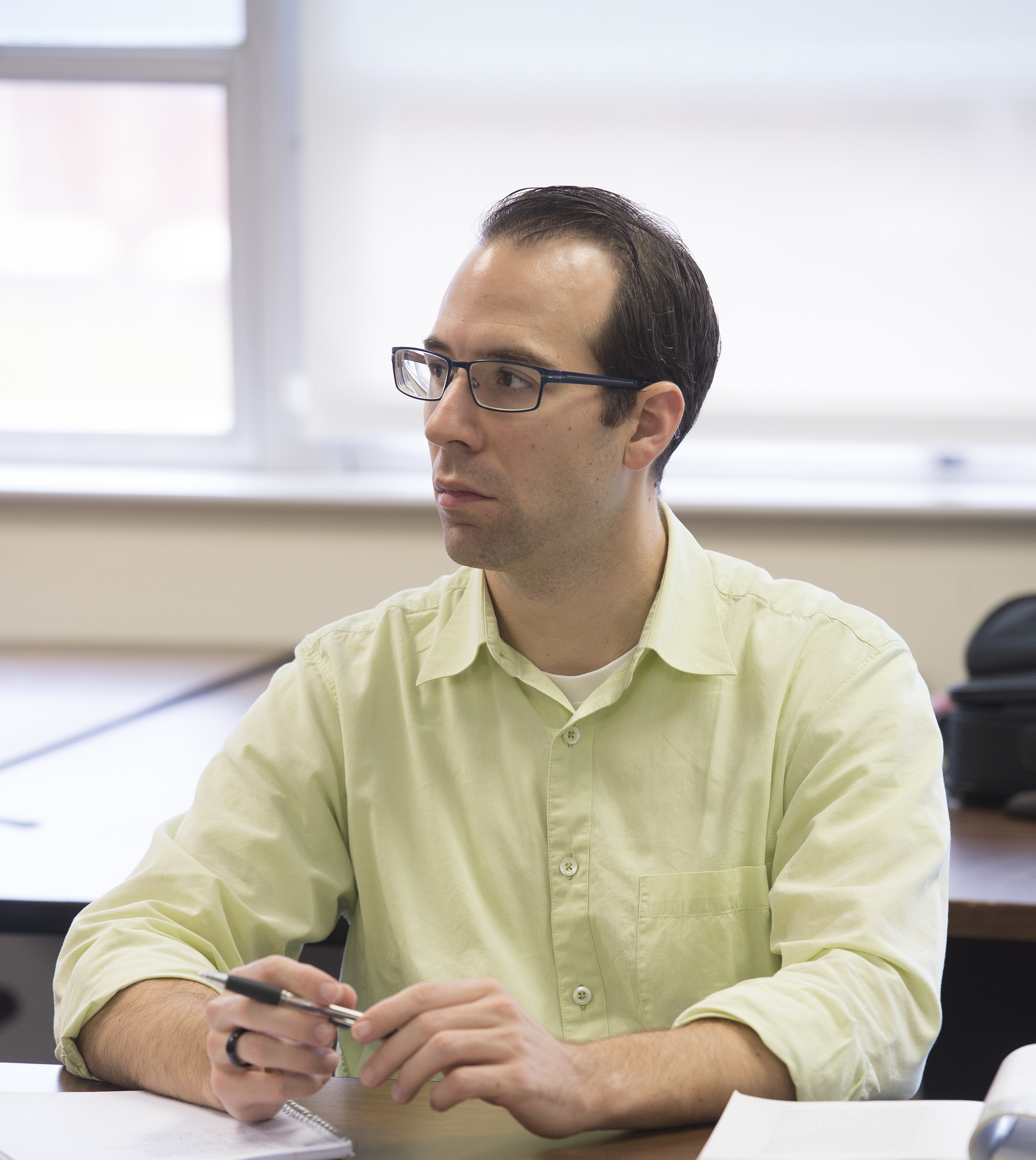 A male Loyola Online student listening in class